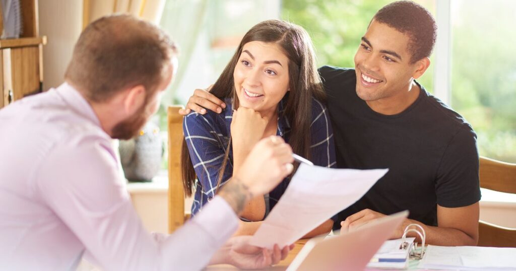 Friendly property advisor discussing freehold and leasehold options with young couple for better property ownership decisions.