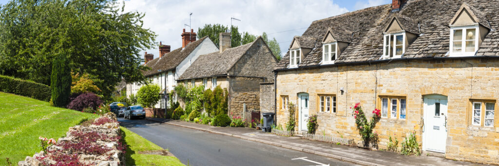 An image showcasing a charming residential street with traditional stone houses, illustrating the concept of fair cash offers on houses.