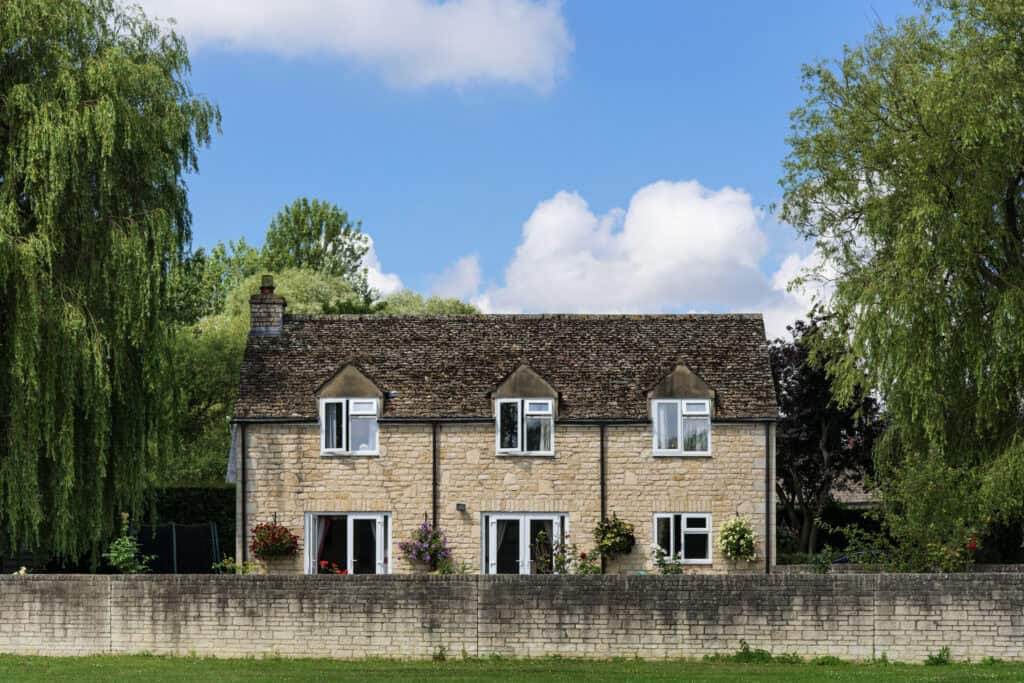 Traditional stone house with a garden, symbolising stability and responsibility, relevant to legal obligations for funeral costs.