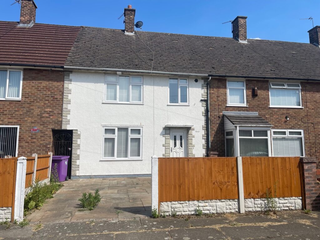 Bright white terraced house with newly painted exterior, front garden, and wooden fence, located in a traditional neighbourhood, showcasing property maintenance and street view in England.