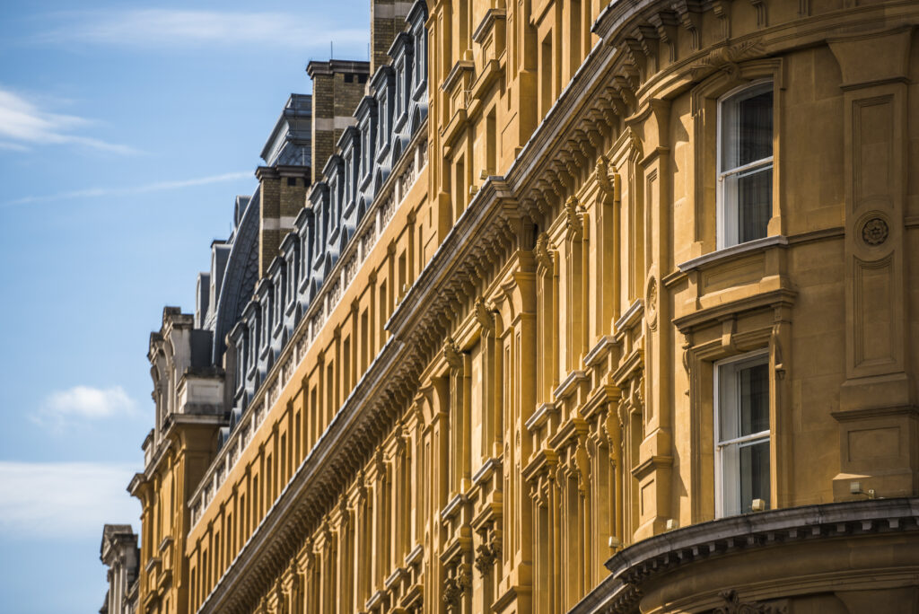 Elegant historic city centre buildings with classic architecture, showcasing intricate facades and large windows, highlighting property preservation and restoration services.