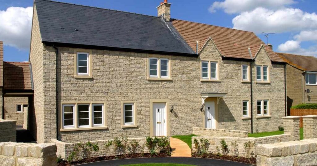 Stone-built residential property with modern UPVC windows, situated in a picturesque neighbourhood, showcasing quality craftsmanship and attractive landscaping, ideal for homebuyers seeking character homes.