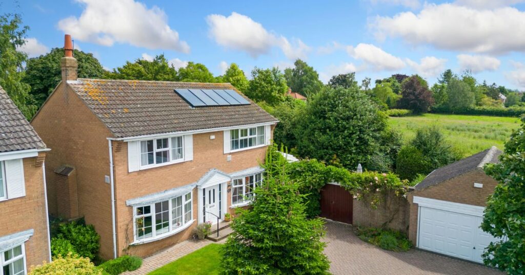 Bright, detached family home with solar panels, lush garden, and spacious driveway in peaceful countryside setting, ideal for property protection and enhancement.