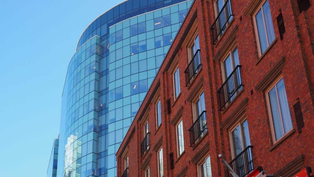 Contemporary commercial building featuring a red brick section and a sleek glass tower, ideal for business or investment purposes.