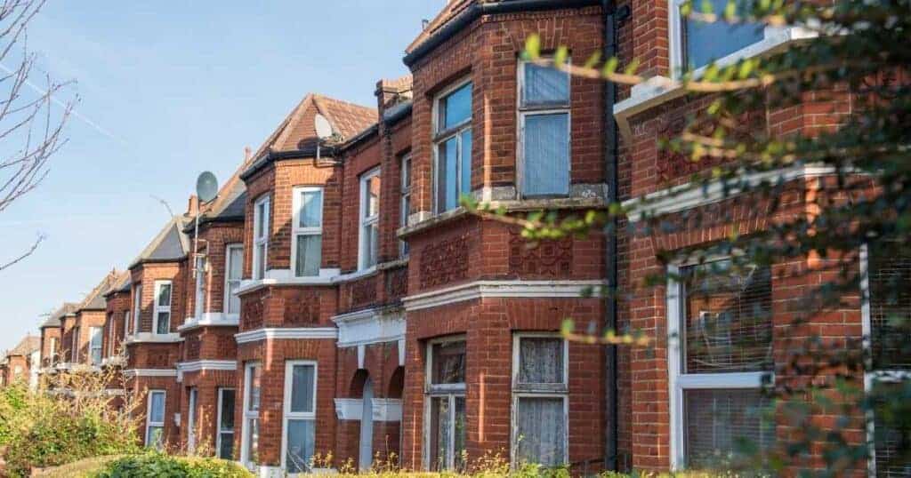 Red brick Victorian terrace housing with bay windows and decorative architectural details, showcasing traditional UK residential architecture.