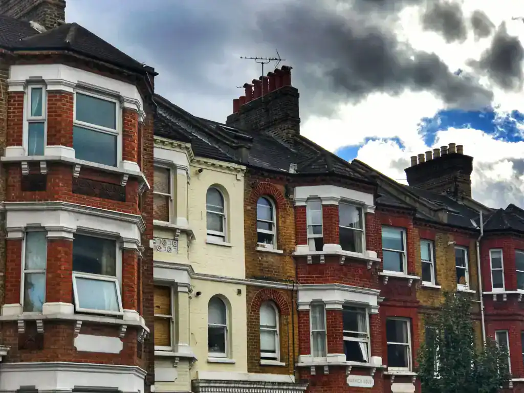 Traditional Victorian terraced house with brick facade and bay windows, situated in a historic London neighbourhood.