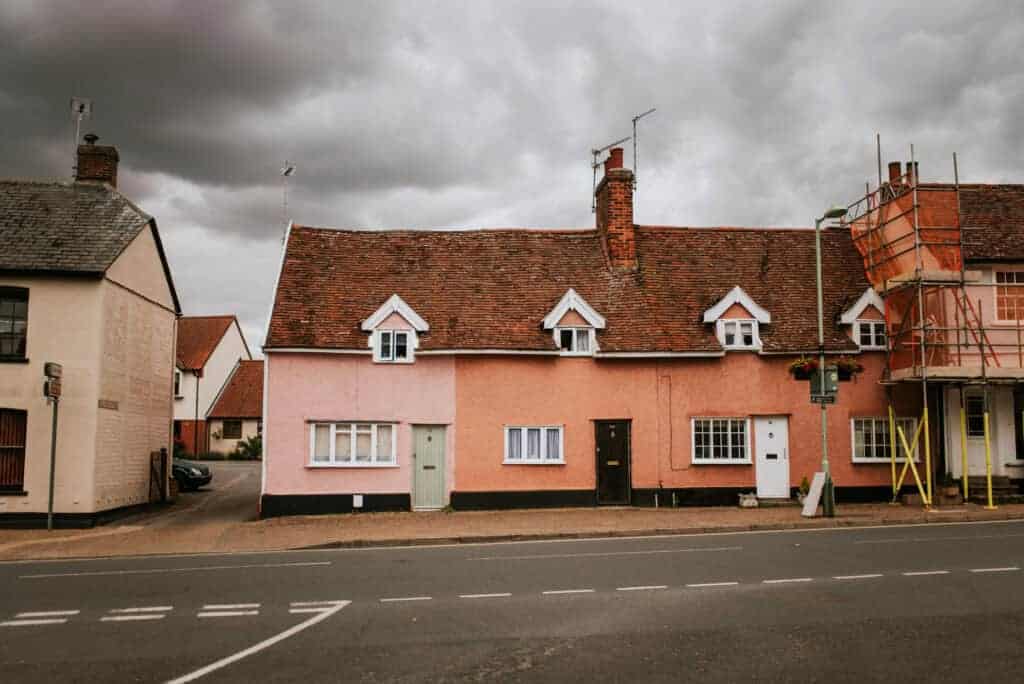 Charming pink terraced house with traditional tiled roof on a cloudy day, showcasing property renovation and maintenance services by Property Saviour in the UK.