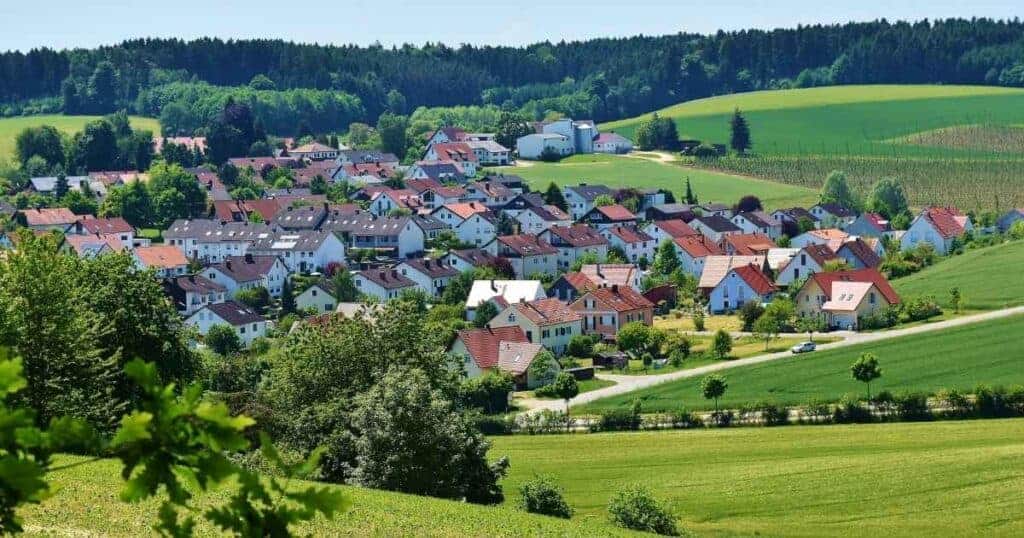 Resilient rural village surrounded by lush green fields and rolling hills, ideal for property preservation services by Property Saviour.