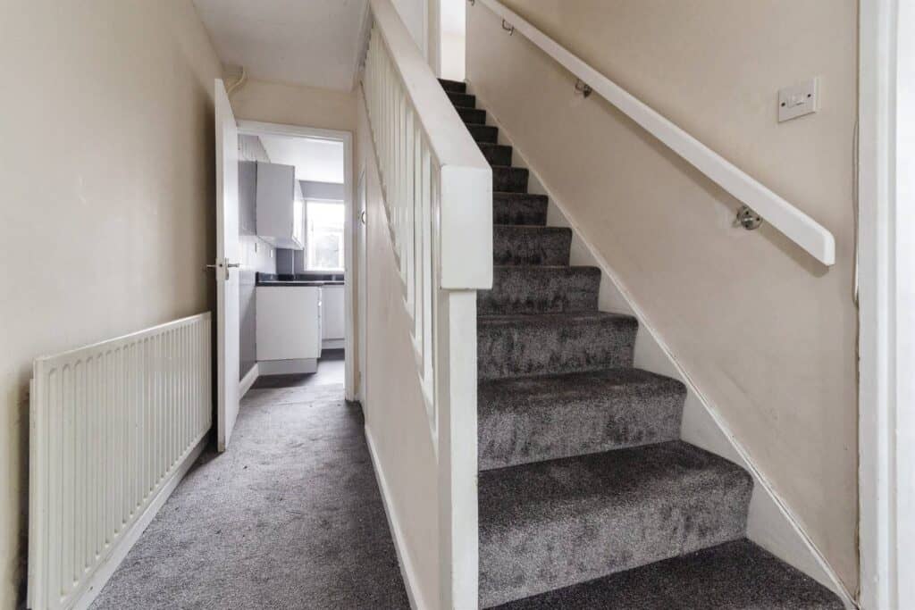 Bright interior view of a house staircase and kitchen, showcasing property maintenance, renovation, and refurbishment services by Property Saviour for homeowner property care.