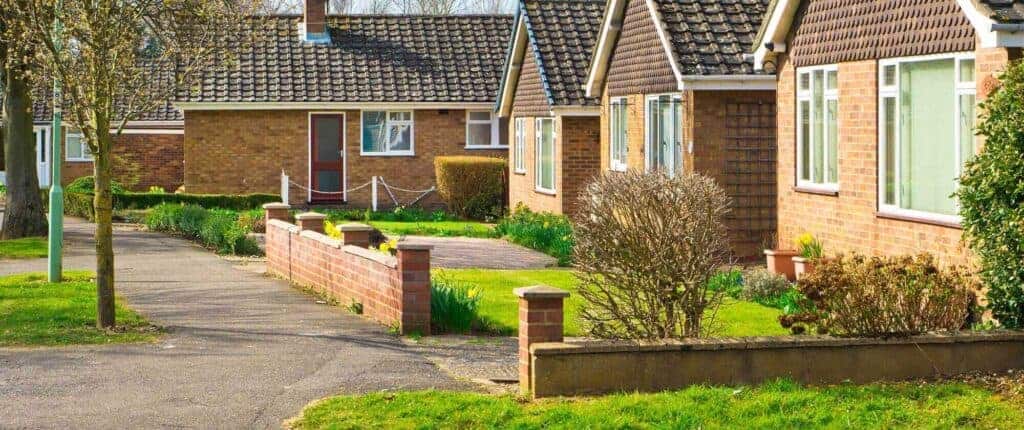 Bright suburban houses with well-maintained gardens, pathways, and brick exteriors showcasing Property Saviour's property management services in the UK.