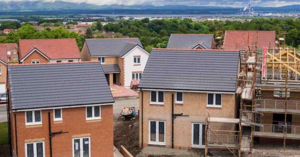 Newly constructed residential houses with scaffolding in a suburban area, under development, modern brick homes, construction site, property development, urban housing project, Property Saviour focus.