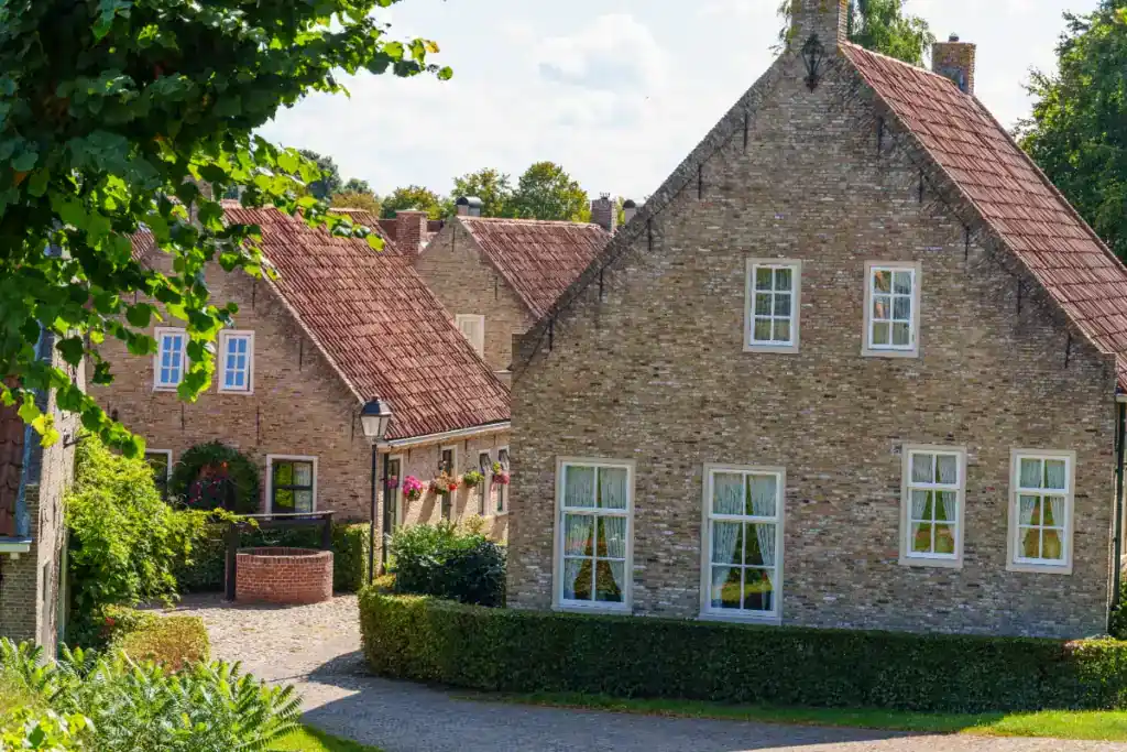 Elegant stone house with lush greenery and well-maintained garden, showcasing a traditional UK home ideal for cash buyers.