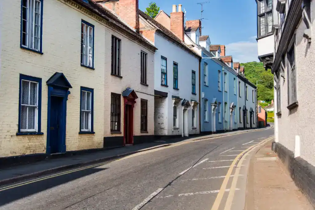 A row of colourful, well-maintained terraced houses on a quiet street, showcasing traditional architecture perfect for HMO property conversions and investment opportunities.