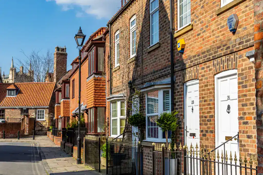 Townhouses with brick facades on a quiet residential street in the UK, illustrating typical property types involved in inheritance and potential tax implications discussed in the article.