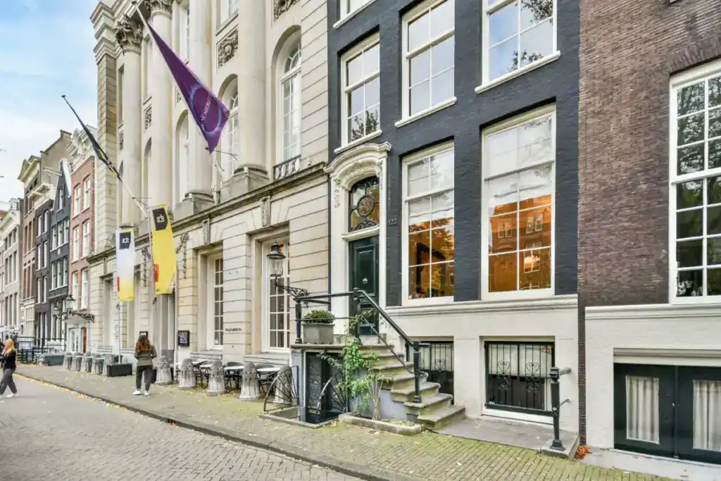 Modern commercial property exterior with historic architecture and flags, highlighting the importance of understanding fees when selling a commercial property.