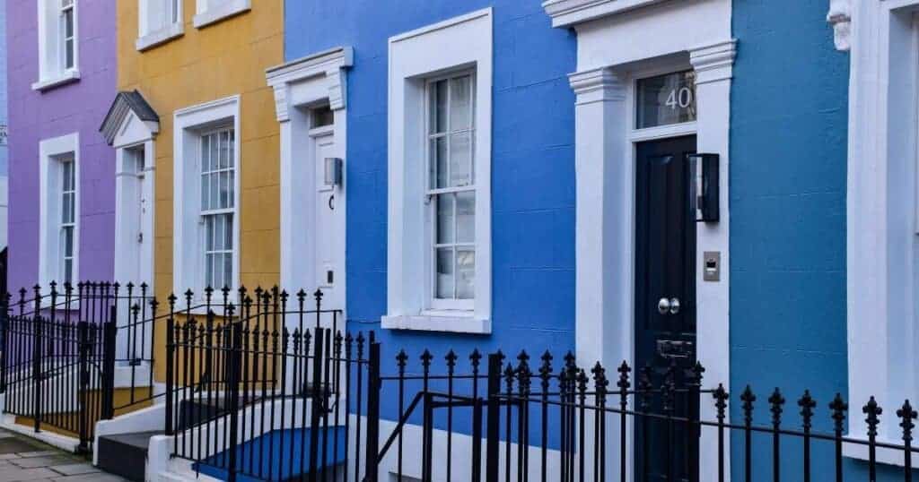 Brightly coloured row houses on a street in Brighton, UK, showcasing vibrant residential architecture. Ideal images for property improvement, property maintenance, or home renovation services.