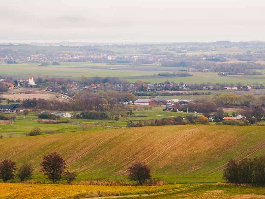 Vast rural landscape with rolling fields, scattered trees, and distant houses showcasing countryside living and property potential in a peaceful setting.