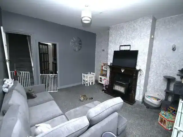 A comfortable living room featuring a grey sofa, a fireplace, and entertainment setup, ideal for relaxing in a budget-friendly home in England.