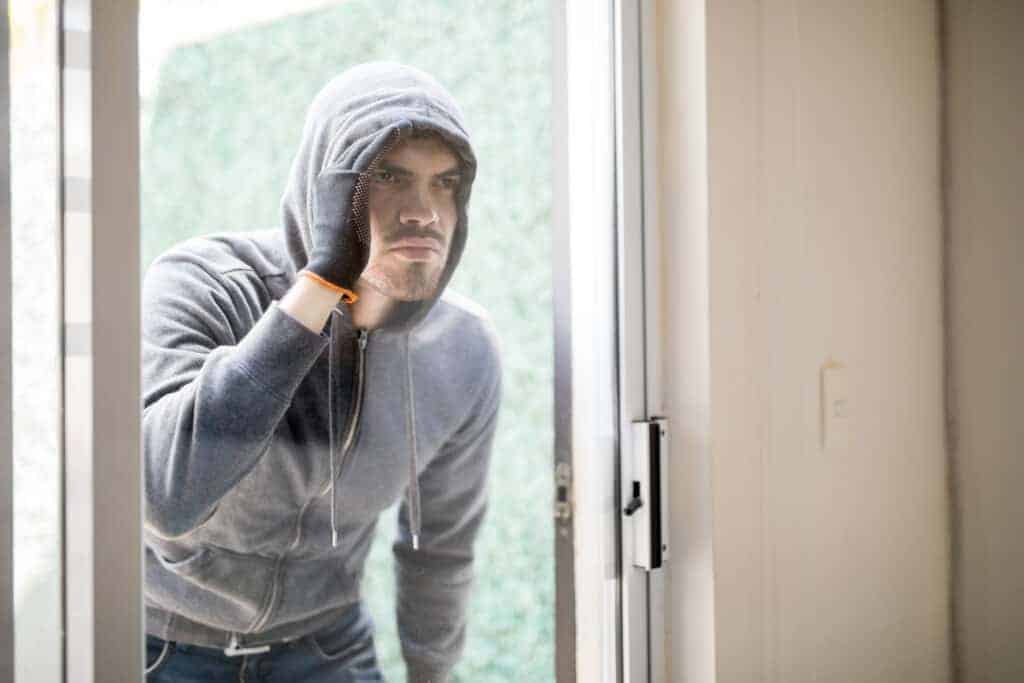 Man inspecting a house door, representing property management and squatter issues, with a focus on selling homes with squatters.