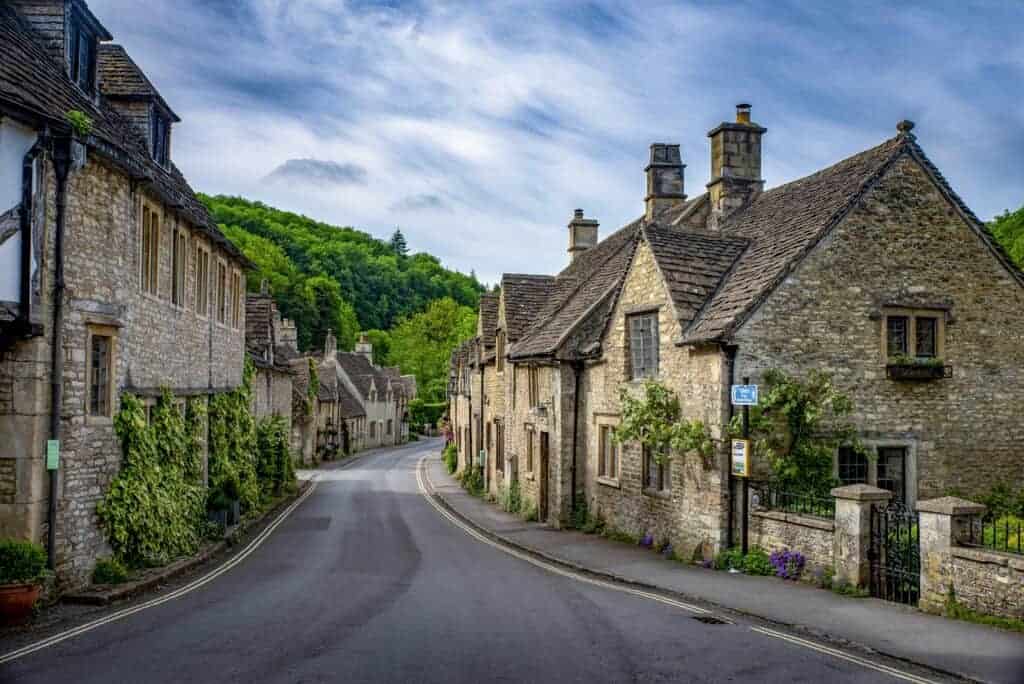 Charming stone cottages in a picturesque village setting, showcasing traditional English architecture near lush green hills, perfect for property restoration and real estate investment.