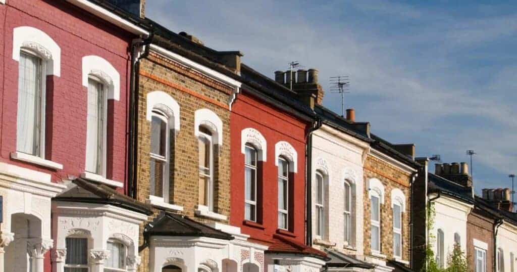 Elegant Victorian terraced houses with colourful facades, historic brickwork, and traditional architectural details in a leafy neighbourhood. Perfect for property investment and city living in the UK.