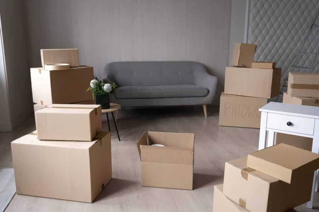 1. Moving house packing and decluttering with cardboard boxes in a modern living room during house removal process.