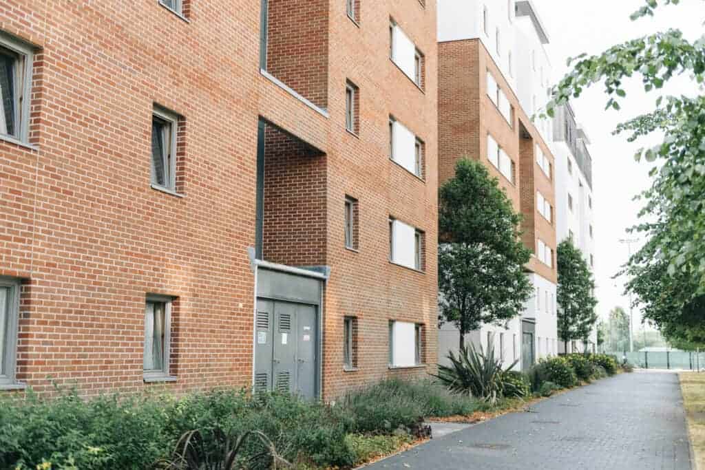 Modern residential apartment building with landscaped surroundings, ideal for quick property sales and real estate solutions.