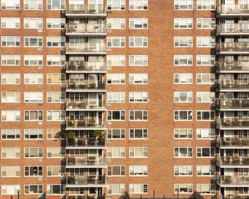 Aerial view of a large residential block of flats with multiple balconies and windows, showcasing urban living accommodation.