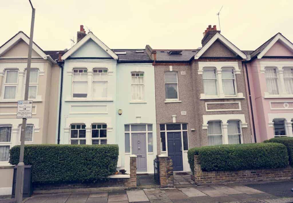 Colourful row of Victorian terraced houses with well-maintained front gardens, ideal for homeowners looking to sell their property quickly through online platforms.