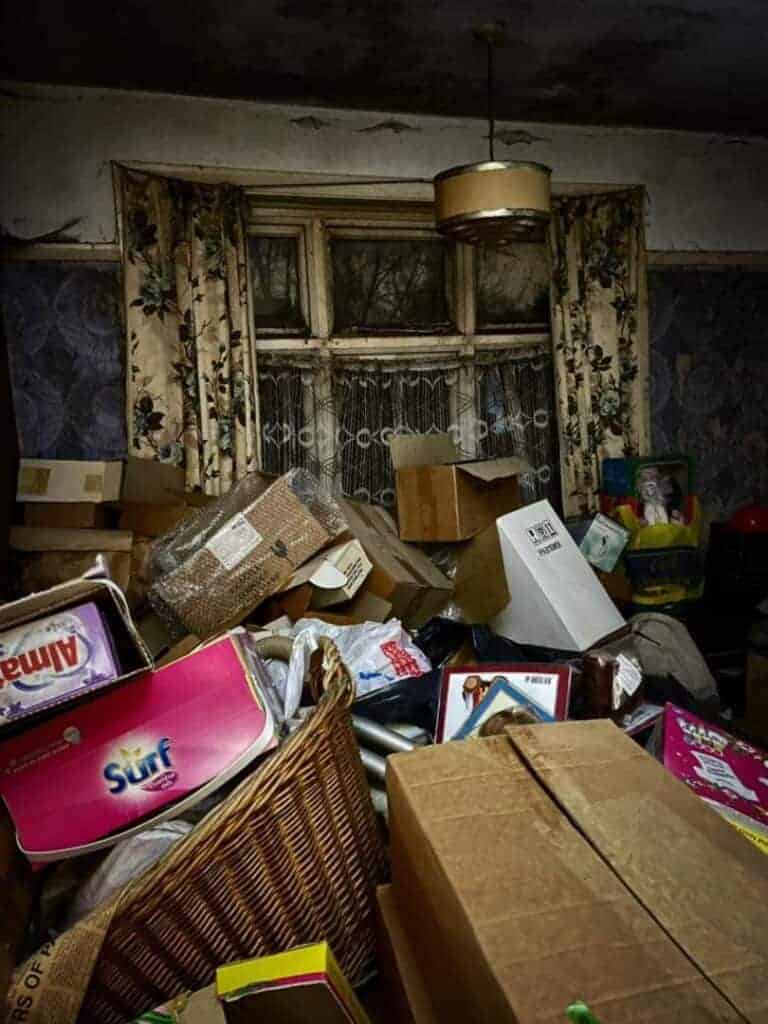 Cluttered and overflowing room filled with boxes, bags, and household items, highlighting the need for professional property clearing and estate cleanout services by Property Saviour.