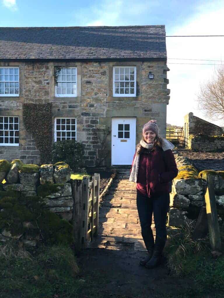 Charming stone cottage exterior with a garden pathway, perfect for property sales.