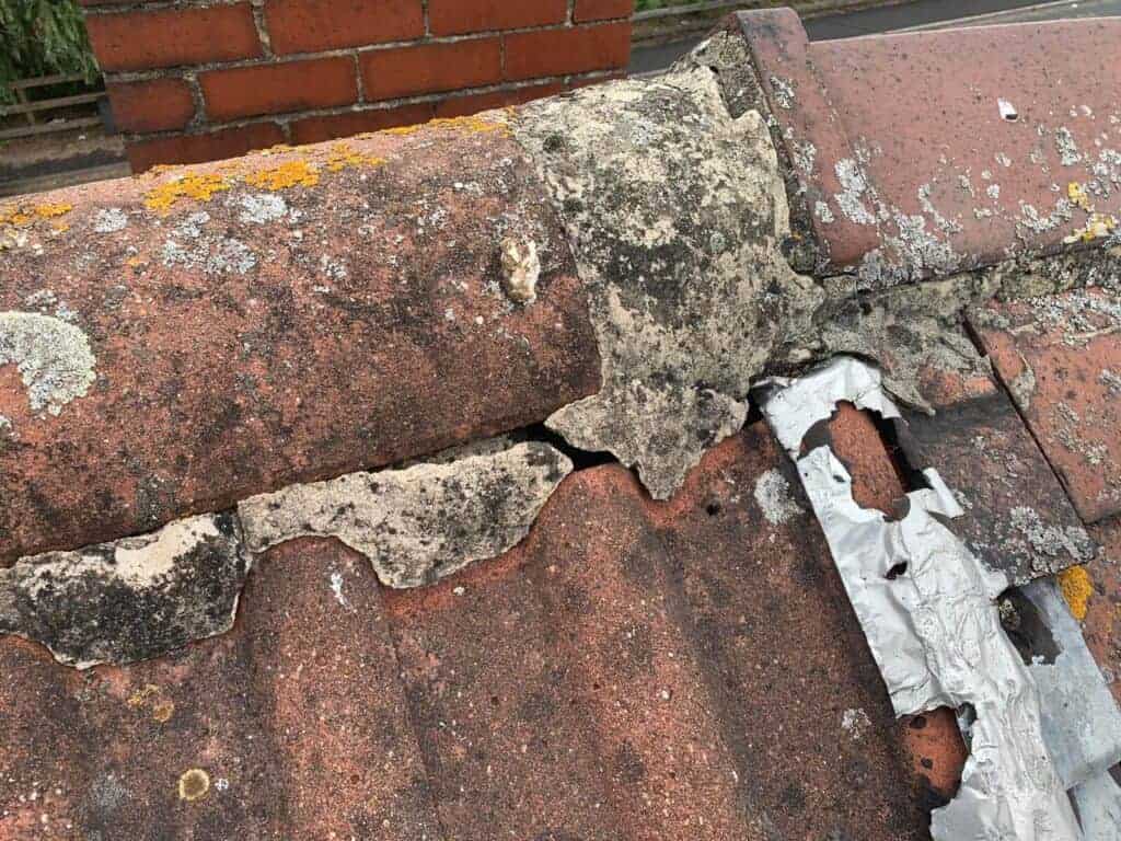Close-up of damaged roof tiles with leaks and deterioration, highlighting the importance of roof repairs for property preservation.